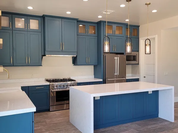 Kitchen cabinets refinished in deep blue with white uppers by ACP Painting