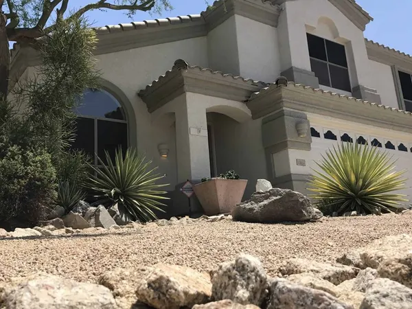 Repainted Arizona home exterior with tile roof and desert landscaping
