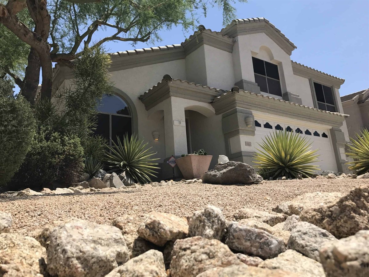 Curb appeal of a freshly repainted Arizona home exterior with desert landscaping