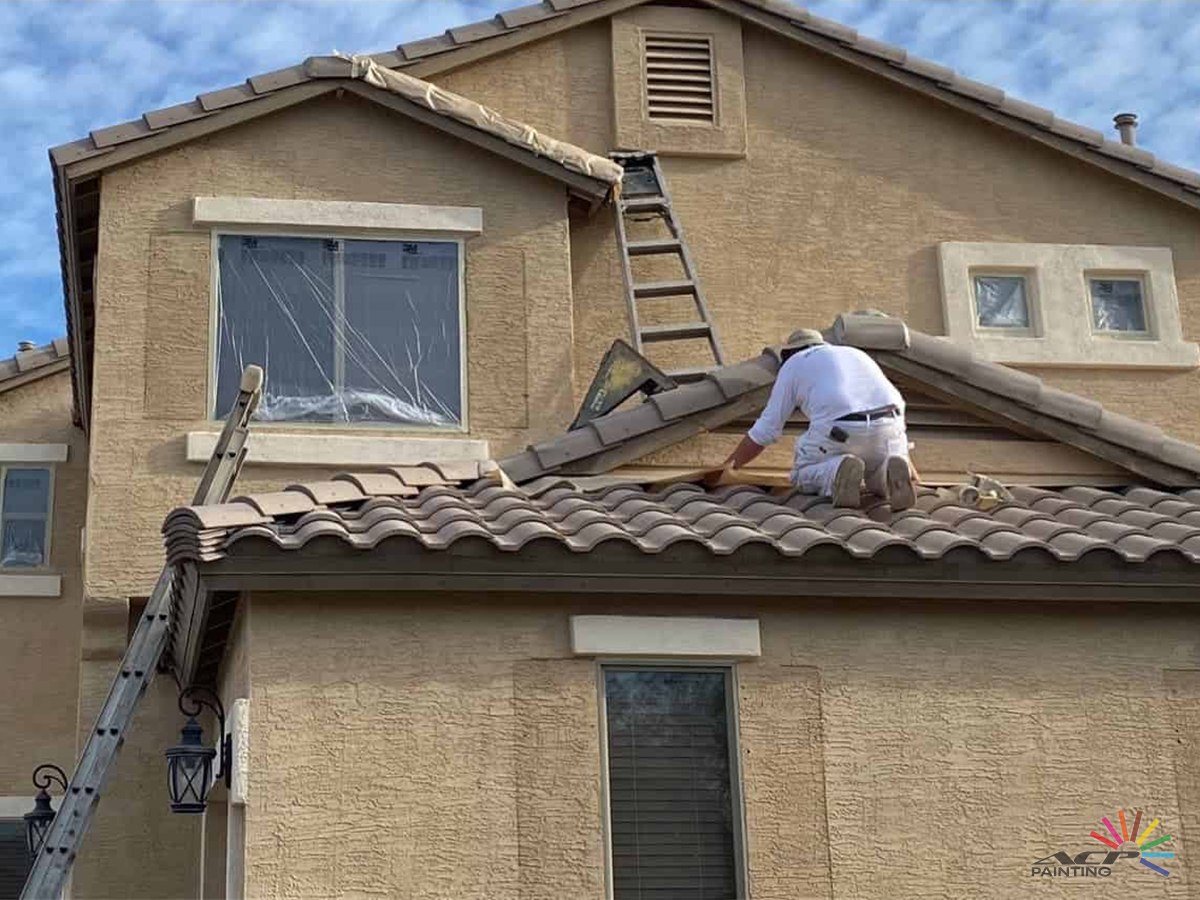 ACP Painting crew member repainting the exterior of a two-story stucco home in Maricopa, AZ