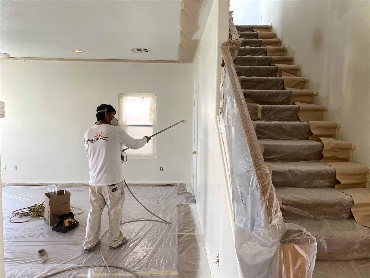 ACP Painting crew member spraying interior walls during a whole-home repaint