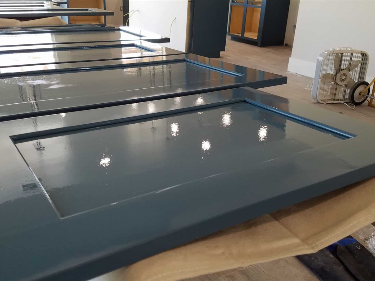 Kitchen cabinet doors laid out and prepped for spraying by ACP Painting
