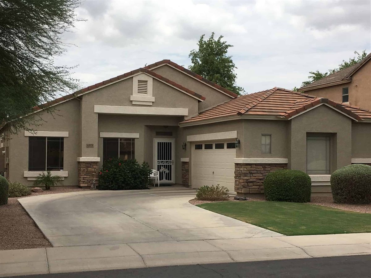 Arizona stucco home with a white security screen door over the front entry beside the garage