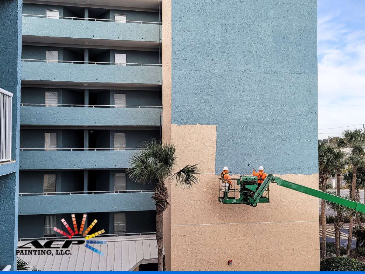 Painters applying paints for commercial exteriors on a building facade using a boom lift.
