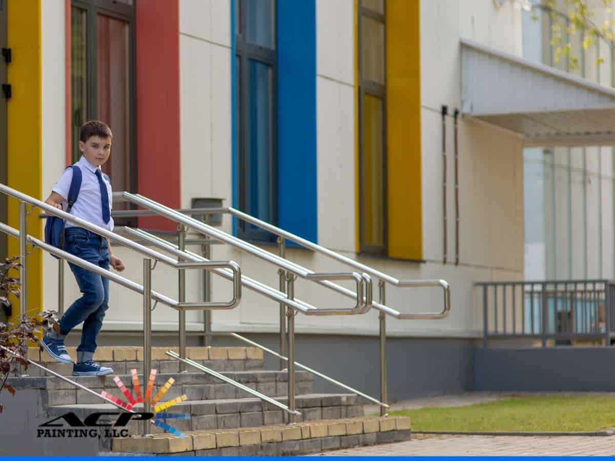 A student walks outside a vibrant, freshly painted building, showcasing the impact of school Painting on a welcoming and engaging learning environment